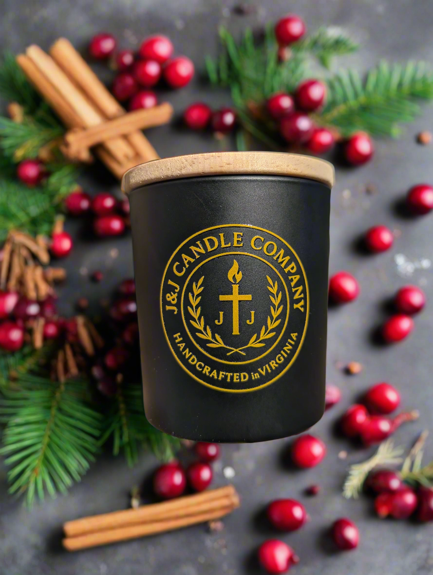 Black candle with a wooden lid featuring the J & J Candle Company. Seasonal fragrance with cranberries and cinnamon